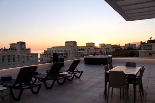 a balcony with chairs and tables and a view of a city at Aqua Apartments Bellamar, Marbella in Marbella