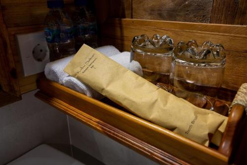 a wooden shelf with towels and glasses on it at Kubu Sakian Villa and Restaurant Sidemen in Silebeng