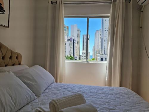 1 dormitorio con 1 cama y ventana con vistas a la ciudad en Apartamento 604 - Centro BC - Vista Mar, en Balneário Camboriú