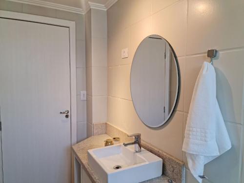 een badkamer met een wastafel en een spiegel bij Apartamento 604 - Centro BC - Vista Mar in Balneário Camboriú
