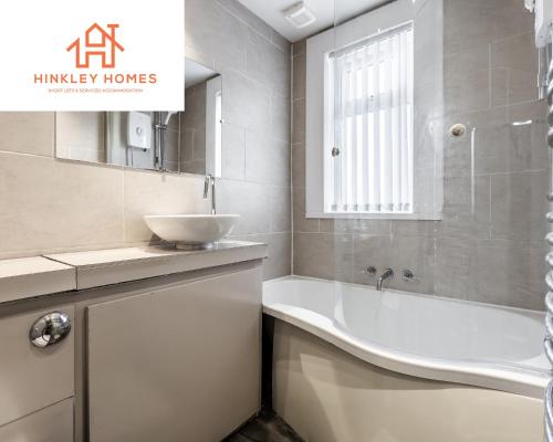 uma casa de banho com um lavatório e uma banheira em Supersized 5bed - Free parking - 8 beds - Anfield - By Hinkley Homes Short Lets & Serviced Accommodation em Liverpool