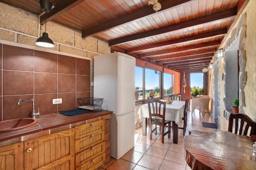 uma cozinha com um frigorífico e uma sala de jantar com uma mesa em Casa el Parral em Vilaflor