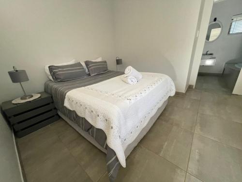 Un dormitorio con una cama con una toalla. en Guest house on Gillian Unit 6 en Ballito