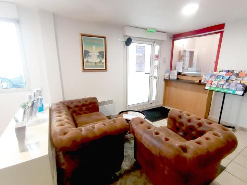 a room with two leather chairs in a store at City Résidence Avignon in Avignon