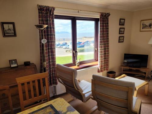 a living room with a window and a table and chairs at Links Quay 42 in Prestwick