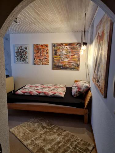 a bed in a room with paintings on the wall at Wald und Felsen - Apartment in Ludwigswinkel