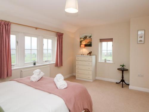 a bedroom with two towels on a bed with windows at Lower Cowden Farm in Bakewell