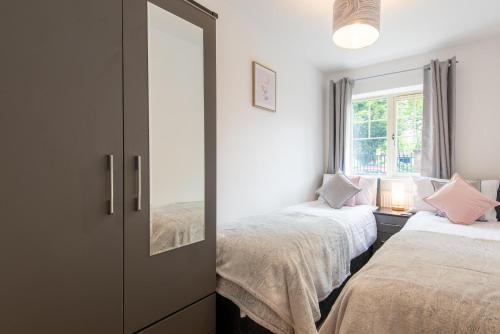 a bedroom with two beds and a mirror at No 21 in Mansfield