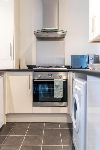 a kitchen with a stove and a dishwasher at No 21 in Mansfield