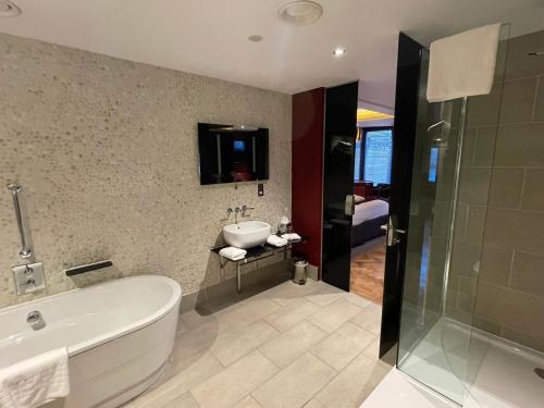 a bathroom with a bath tub and a sink at Le Monde Hotel in Edinburgh