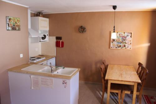 a kitchen with a sink and a table with chairs at Le Silence du Midi in Comus