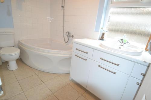 ein Badezimmer mit einem Waschbecken, einem WC und einer Badewanne in der Unterkunft Sea Grove in Ventnor