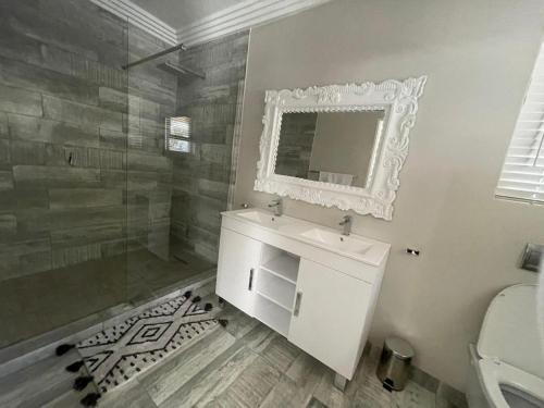 a bathroom with a sink and a shower and a mirror at Guest house on Gillian Unit 7 in Ballito