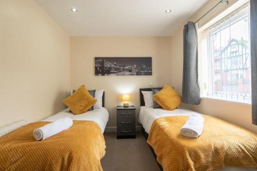 two twin beds in a room with a window at Apartment 8 in Worksop