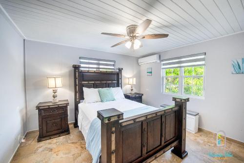 a bedroom with a bed and a ceiling fan at Dover Court Apartments - Steps to St Lawrence Gap in Christ Church
