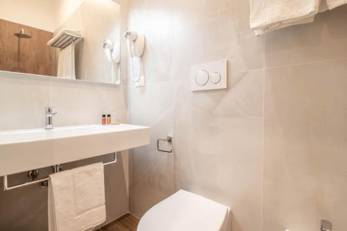 a white bathroom with a sink and a toilet at DANY GUEST HOUSE in Rome