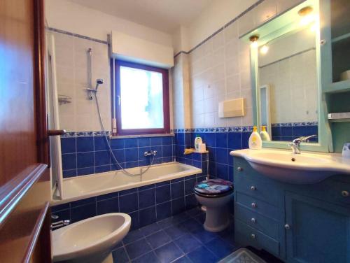 a blue bathroom with a sink and a toilet at Villetta Acilia, 4 ospiti, giardino, parcheggio privato in Acilia
