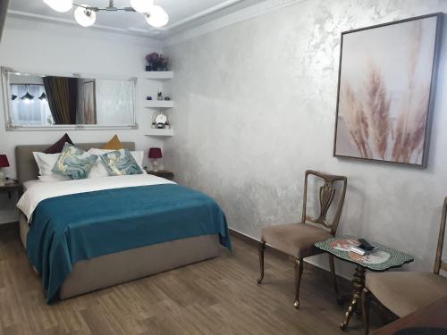 a bedroom with a bed and a chair at Studio Sofia in Râmnicu Vâlcea