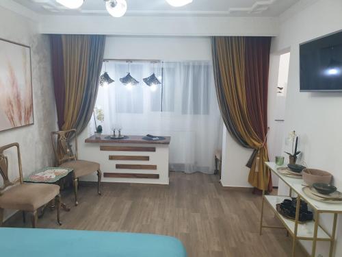 a room with a bed and a desk and a window at Studio Sofia in Râmnicu Vâlcea