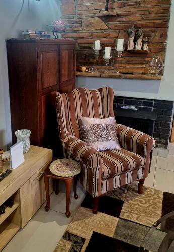 a living room with a chair and a fireplace at Isabel's B & B in Krugersdorp