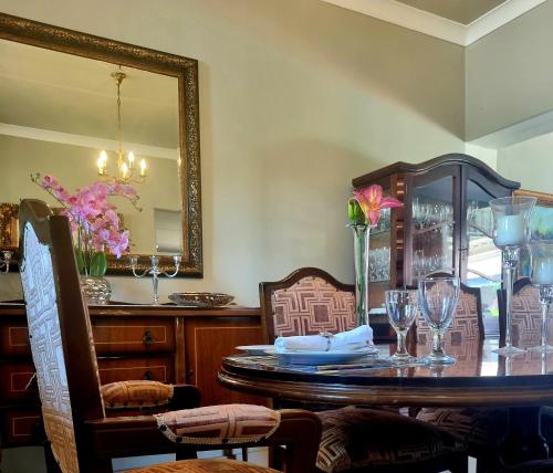 a dining room with a table and a mirror at Isabel's B & B in Krugersdorp