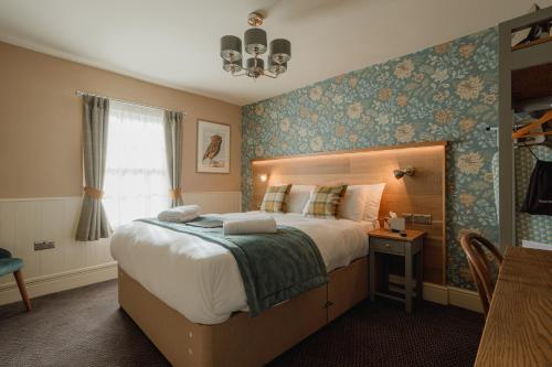 a bedroom with a large bed and a window at The Bell in Solihull