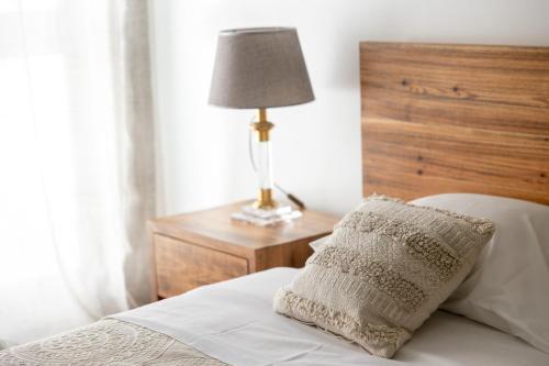 a bed with a pillow and a lamp on a table at TMO Residence 2 in Ponta Delgada