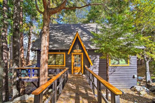 a cabin in the woods with a wooden walkway to the door at Pet-Friendly Retreat with Game Room and Fire Pit! in Lake Arrowhead
