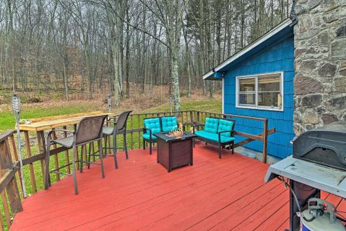 a blue house with chairs and a table on a deck at Cozy Catskills Escape, 3 Mi to Plattekill Mtn in Roxbury