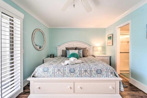 a bedroom with a white bed and a mirror at Bright Carolina Beach Condo - Walk to Shore! in Carolina Beach