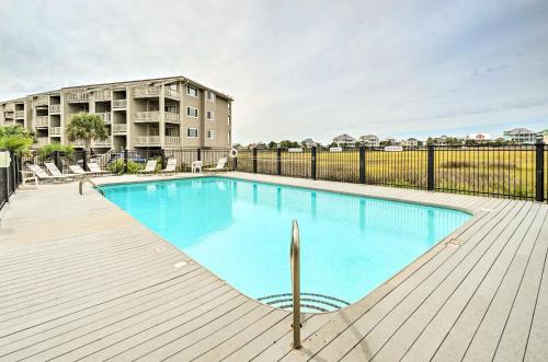 a swimming pool on a deck next to a building at Bright Carolina Beach Condo - Walk to Shore! in Carolina Beach