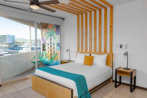 1 dormitorio con 1 cama y balcón en Mayan Monkey Los Cabos en Cabo San Lucas