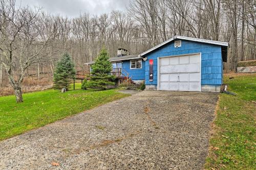 a blue house with a white garage in a yard at Cozy Catskills Escape, 3 Mi to Plattekill Mtn in Roxbury