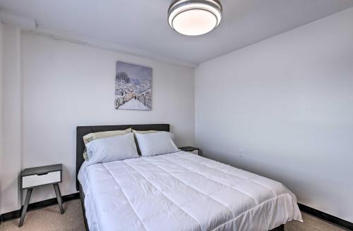 a bedroom with a large white bed with a lamp at Airy Apt Situated in the Coosa River Area! in Gadsden