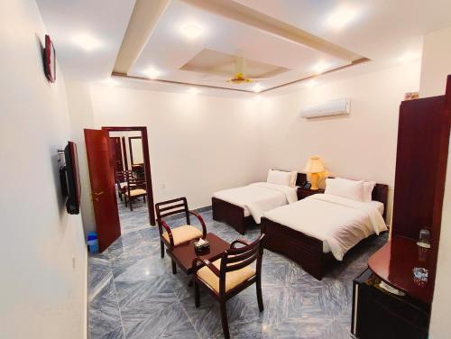 una camera d'albergo con due letti e un tavolo con sedie di Hotel Nova a Lahore