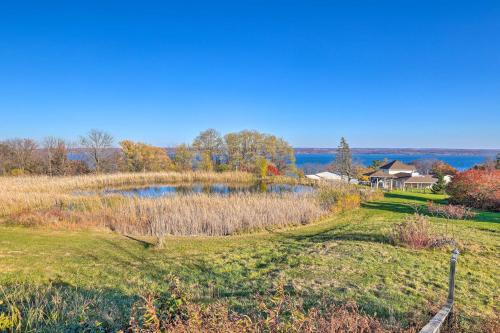 an open field with a house on a hill with a pond at Lakefront Romulus Retreat with Private Dock! in Romulus
