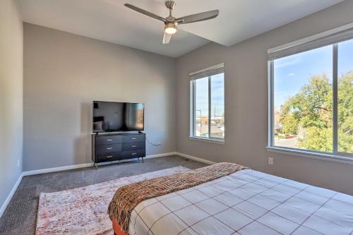a bedroom with a bed and a tv and windows at 6 Mi to Dtwn Denver Townhome with Patio! in Thornton