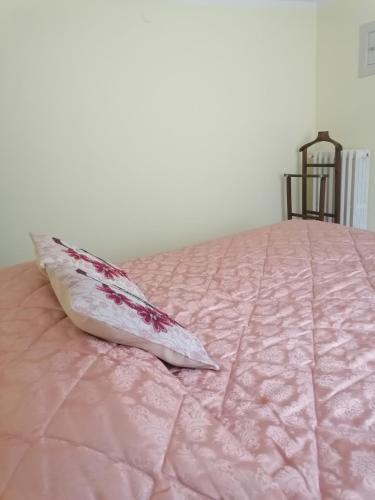 Apartment Maria في إينّا: وسادة جالسة فوق سرير وردي