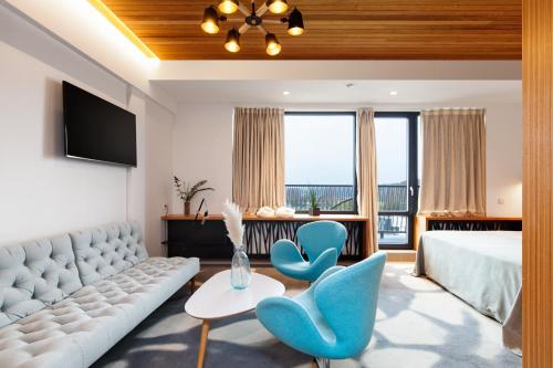 a hotel room with a couch and two blue chairs at Vytautas Mineral SPA in Birštonas