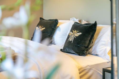 a bed with two black pillows on it at Sunny Luxurious 2 bedroom Holiday cottage in Embsay