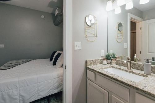 a bathroom with a bed and a sink and a mirror at The Sanctuary Company Johnson City in Johnson City
