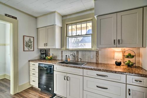 a kitchen with white cabinets and a sink and a window at Family-Friendly Des Moines Retreat with Patio! in Des Moines