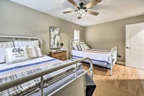 a bedroom with two beds and a ceiling fan at Lakefront Rogers Getaway with Hot Tub and Deck! in Rogers