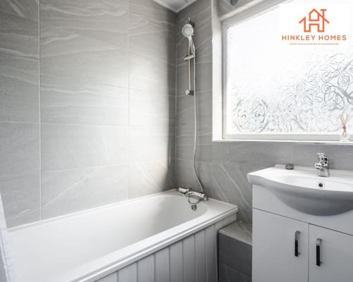 a bathroom with a tub and a sink and a window at Spacious 3 bedroom house with wifi and car parking By Hinkley Homes Short Lets & Serviced Accommodation in Waterloo