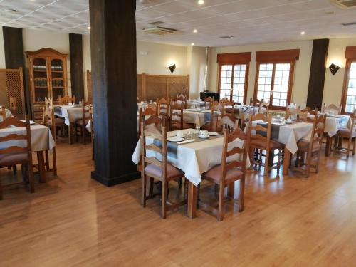 una sala da pranzo con tavoli e sedie con tovaglia bianca di Hotel Rural Villa de Vinuesa a Vinuesa