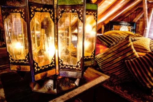 a room with a bed with a stained glass lamp at Bijou Hotel / Love and Romance in Kallnach