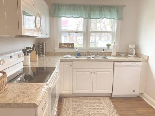 a kitchen with white cabinets and a sink and a window at The Rustic Retreat- close to downtown in Bristol