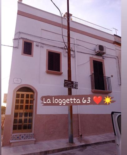 a building with a sign that reads la locaciocrica l at La loggetta 63 in Palagianello