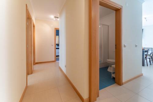 um corredor com uma porta que leva a um quarto com WC em Apartamento T3 Beira Mar na Nazaré