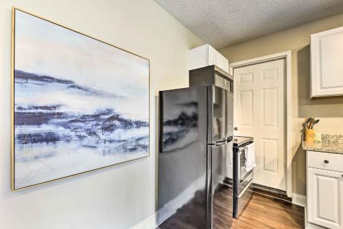 a kitchen with a refrigerator and a painting on the wall at Modest Huntsville Studio with Full Kitchen! in Huntsville